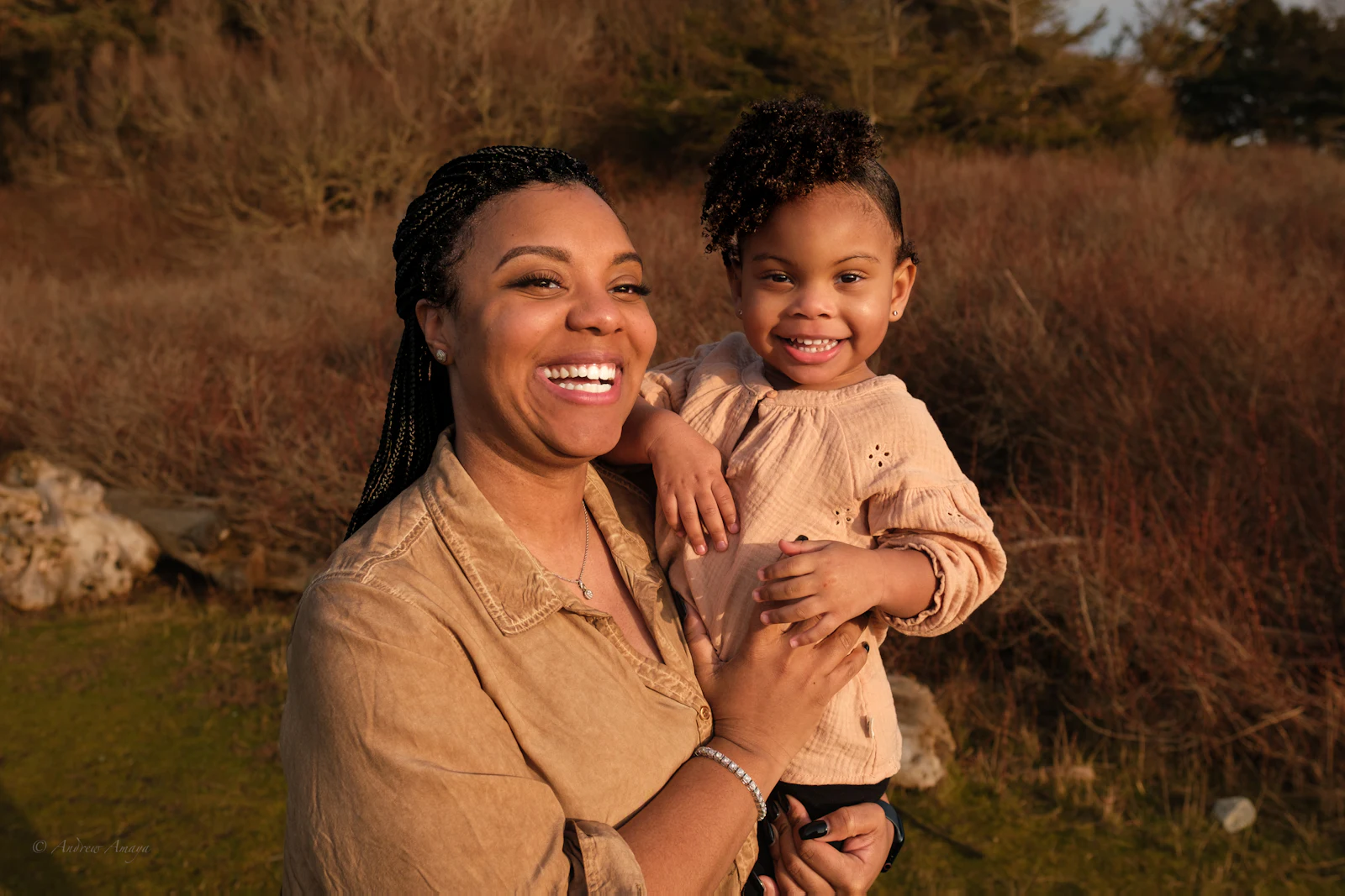 A mother holding her young daughter outdoors